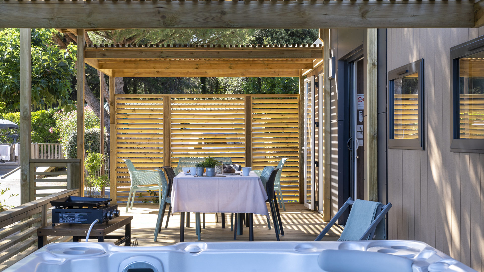Terrasse avec jacuzzi et table à manger.
