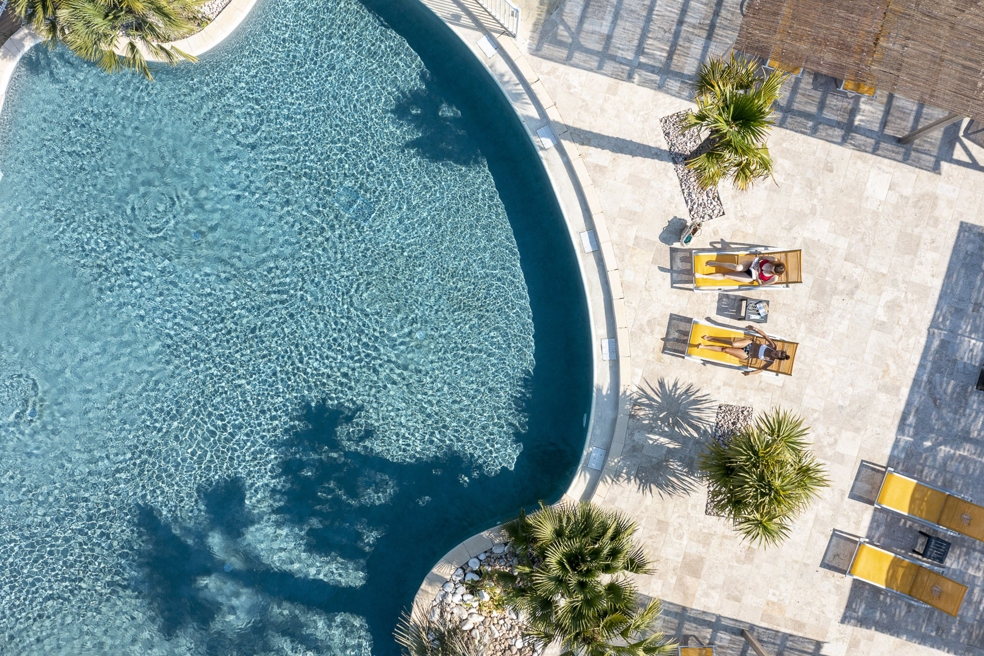 Deux personnes allongées sur des transats proches d'une piscine