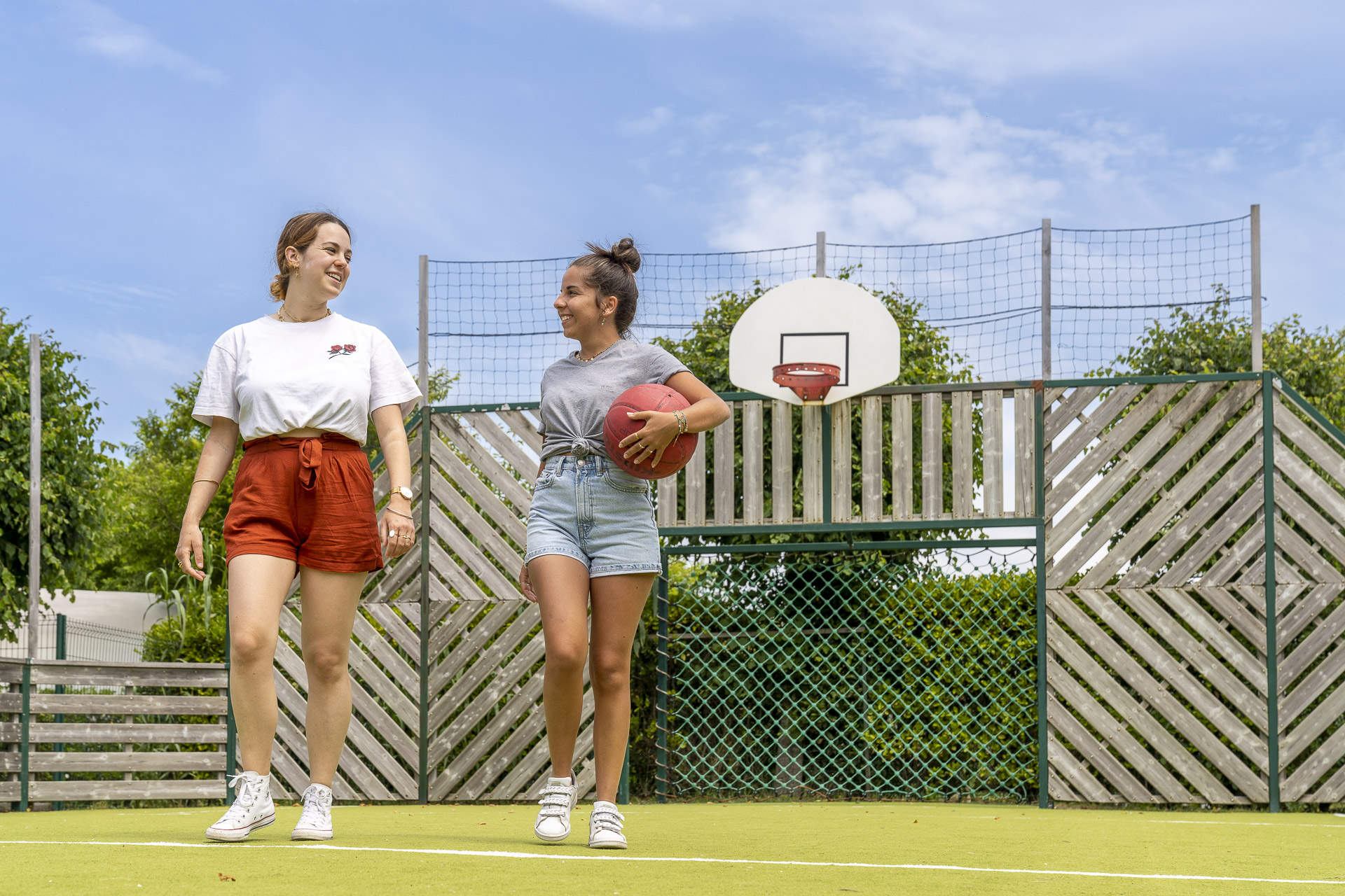 Twee vrouwen die over een basketbalveld lopen