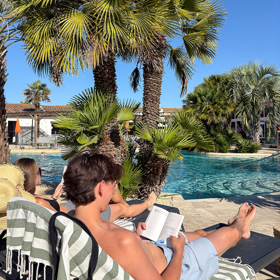 Deux personnes qui lisent au bord d'une piscine