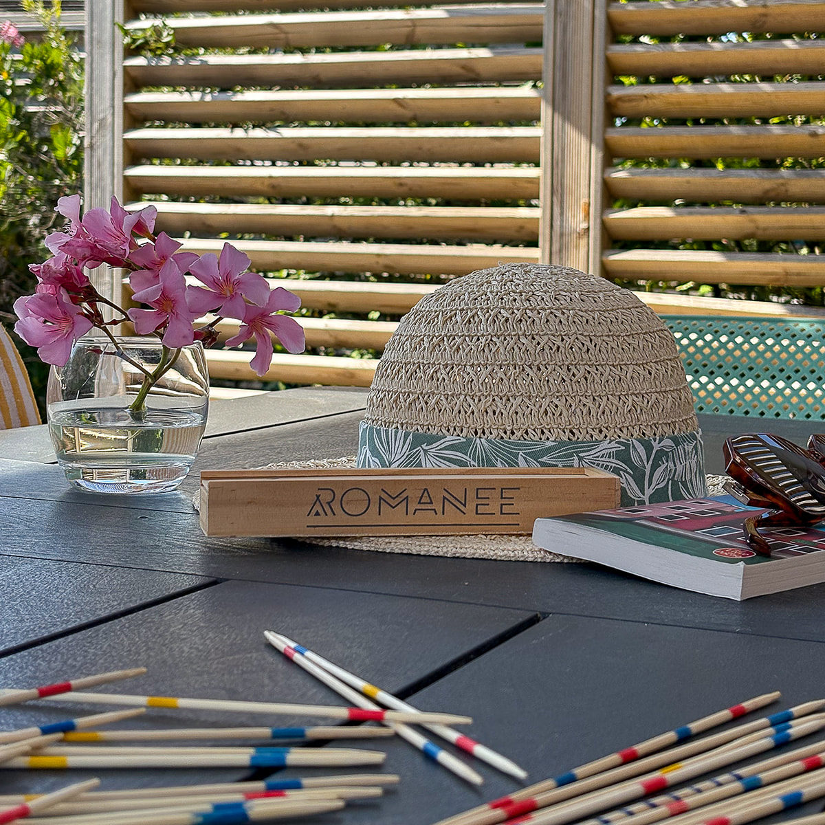 Table avec jeu de mikado, chapeau et livre
