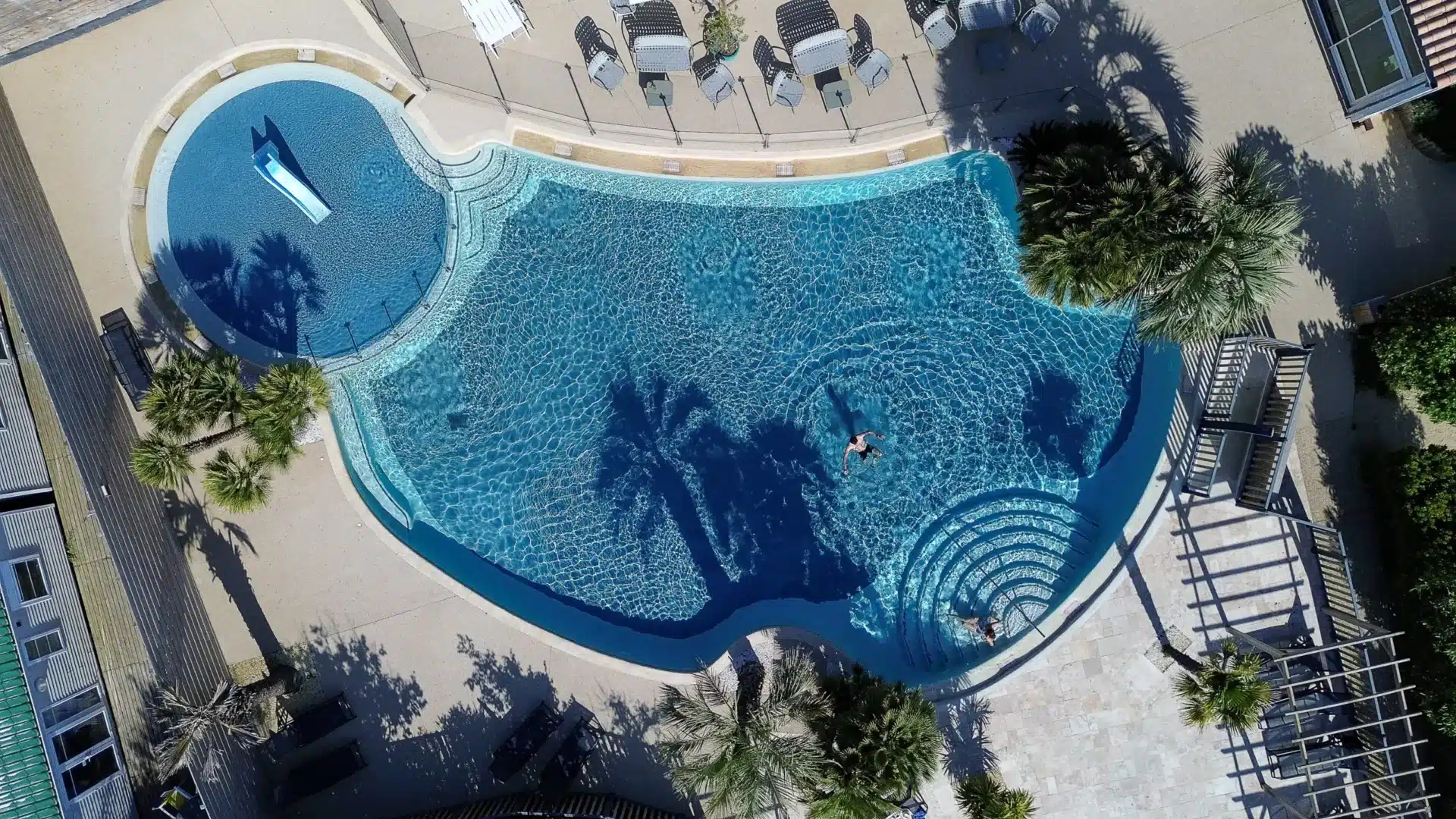 Vue aérienne d'une grande piscine ensoleillée.